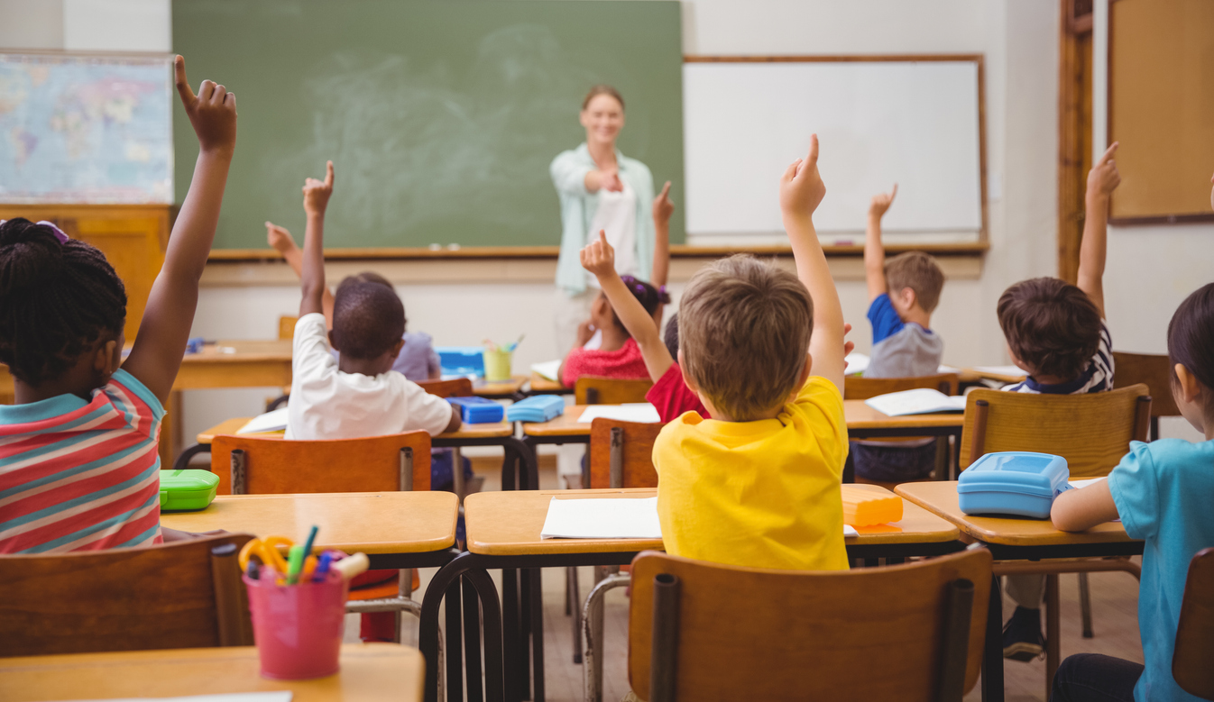 Students raising their hands during class